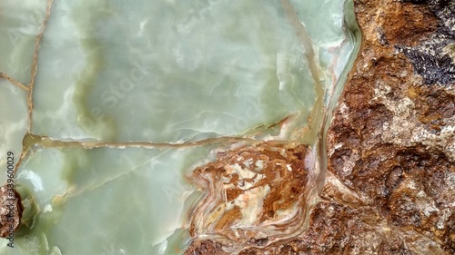 Green onyx tile with orange weaves. Background texture for design.