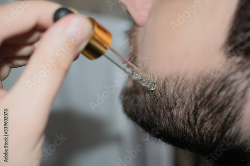 Adult man takes care of his beard: close-up, banner, barbershop concept
