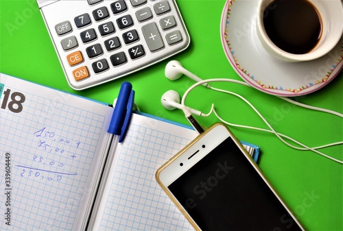 lavoro in ufficio con cellulare penna  tazza di caffè  agenda calcolatrice per fare calcoli numerici photo