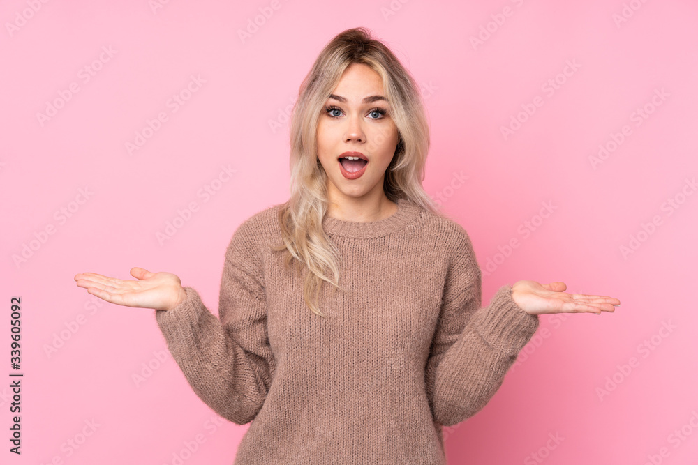 Teenager blonde girl wearing a sweater over isolated pink background with shocked facial expression Teenager blonde girl wearing a sweater over isolated pink background with shocked facial expression