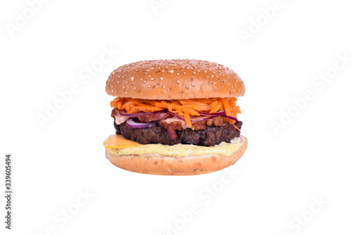 Fresh burger with pork and beef cutlet, bacon, cheddar cheese, korean carrots, pickled onions, caesar sauce isolated on white background.