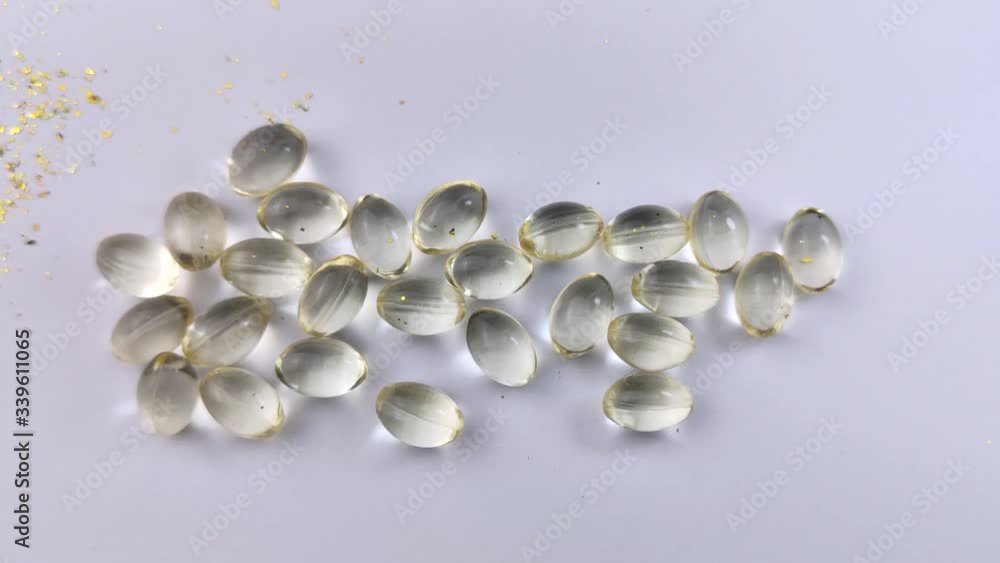 Vitamin D3 capsules lie on a white background. The beam of light passes smoothly through the capsules creating an illusion of the internal glow of vitamins. Health care Vitamin D3 capsules lie on a white background. The beam of light passes smoothly through the capsules creating an illusion of the internal glow of vitamins. Health care