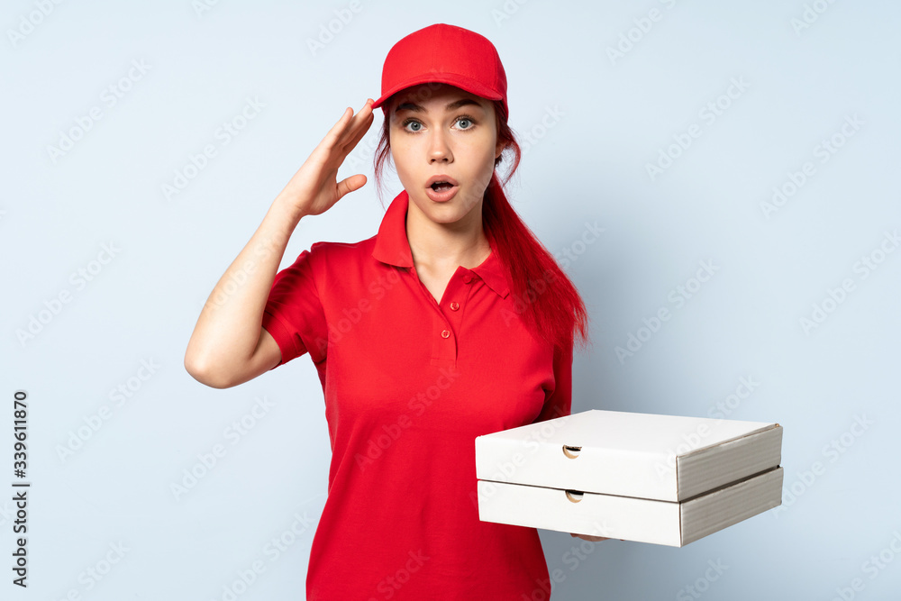 Pizza delivery girl holding a pizza over isolated background has realized something and intending the solution Pizza delivery girl holding a pizza over isolated background has realized something and intending the solution