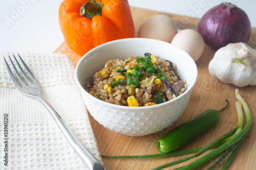 Chinese style vegetarian egg fried rice with sweet corn, green peas, onions, garlic, mushrooms and scallions