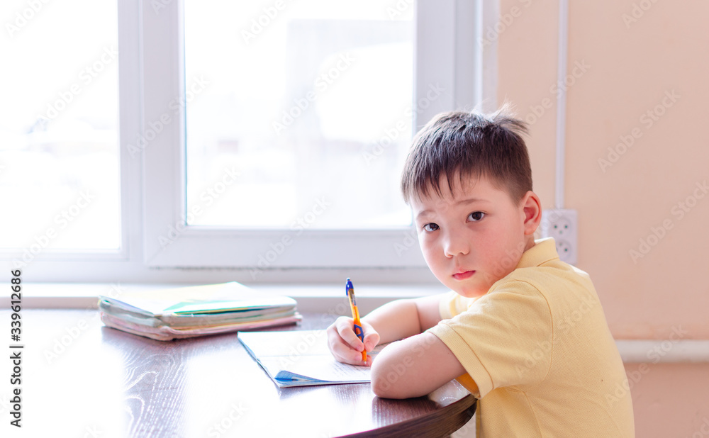 Asian child boy student in medical face mask homework online lesson at home, epidemic Coronavirus, MERS-CoV, 2019-nCoV, quarantine, Covid-19 self-isolation, online education, home schooling Asian child boy student in medical face mask homework online lesson at home, epidemic Coronavirus, MERS-CoV, 2019-nCoV, quarantine, Covid-19 self-isolation, online education, home schooling