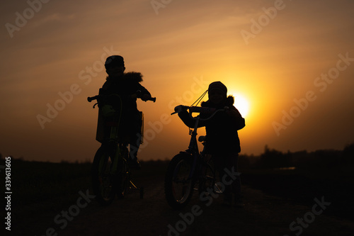 children on bicycles at sunset