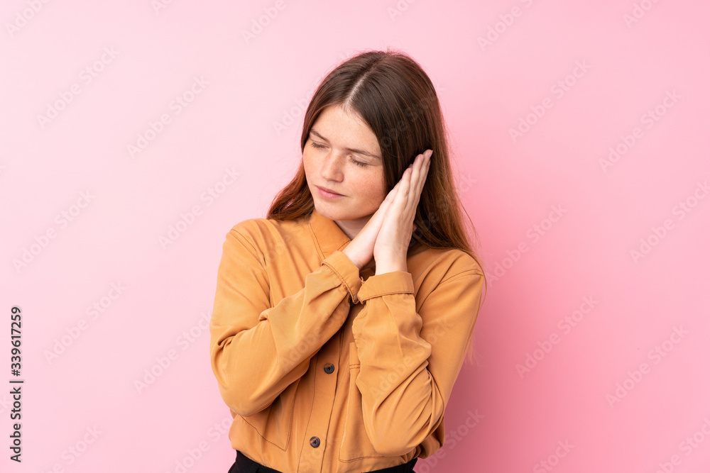 Ukrainian teenager girl over isolated pink background making sleep gesture in dorable expression Ukrainian teenager girl over isolated pink background making sleep gesture in dorable expression
