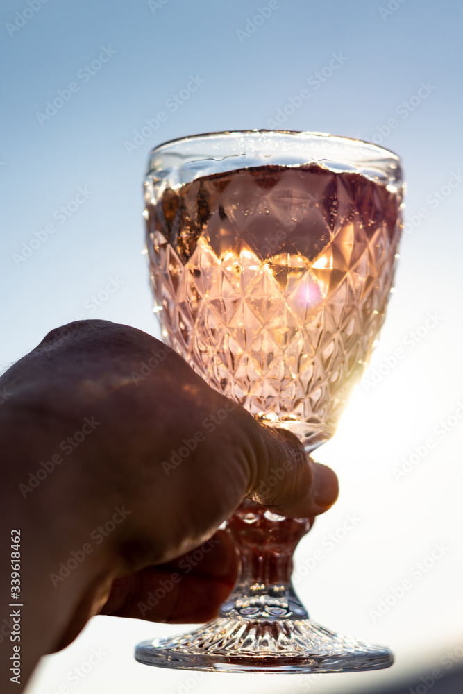 Volles Cocktailglas Wird In Die Sonne Gehalten Mit Lichtreflexen Und volles-cocktailglas-wird-in-die-sonne-gehalten-mit-lichtreflexen-und