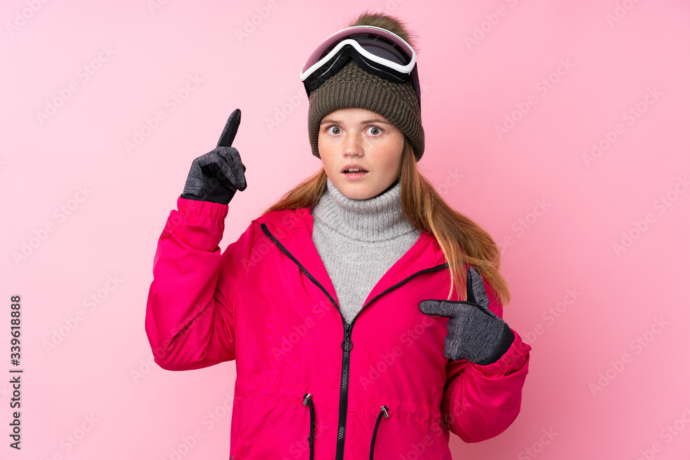 Ukrainian teenager skier girl with snowboarding glasses over isolated pink background with surprise facial expression