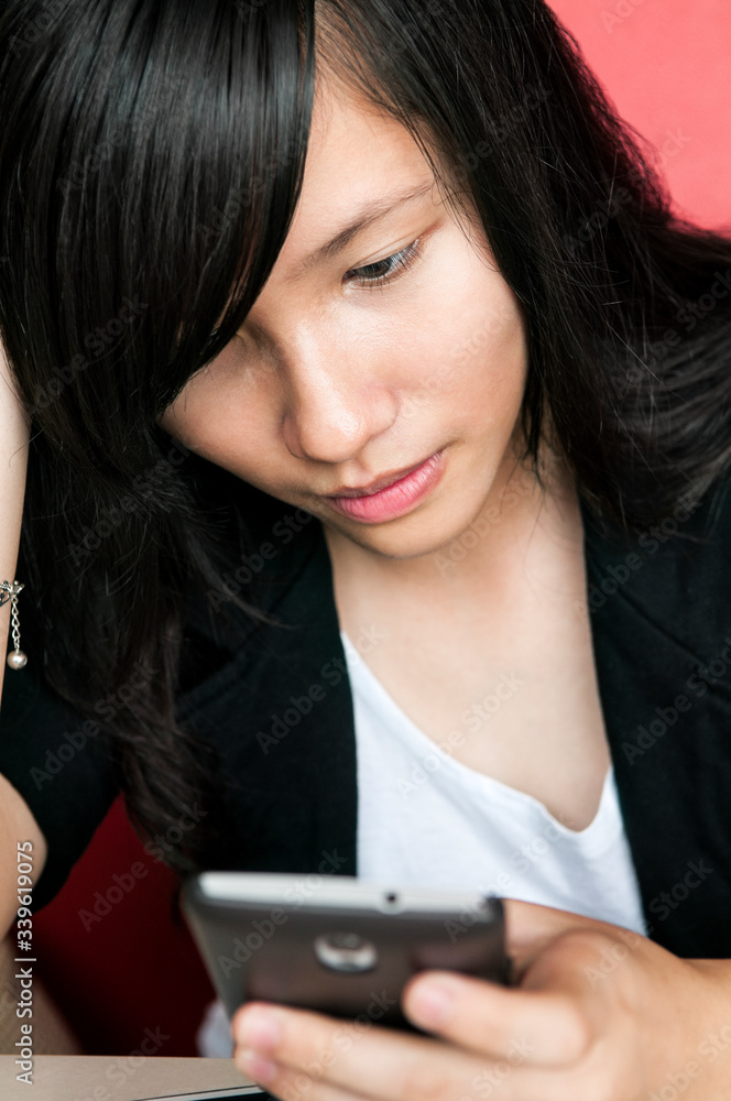 Close-up of young woman using smartphone at home. Close-up of young woman using smartphone at home.