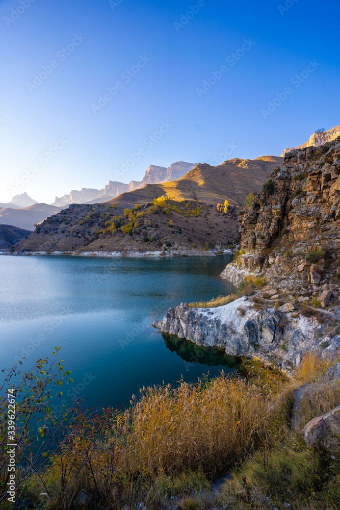 Naklejka premium mountain landscape with a lake at sunset
