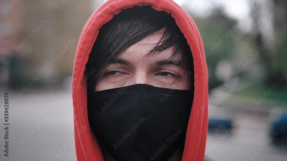 Close-up portrait of young man in protective mask standing outdoors, seasonal flu epidemic in country. Close-up portrait of young man in protective mask standing outdoors, seasonal flu epidemic in country.