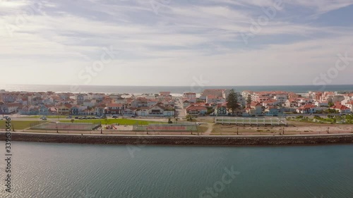 Flight over an traditional portuguese fisherman village in Costa Nova do Prado, Portugal. Street with colorful and striped houses. A drone flies over the village to the Atlantic Ocean.