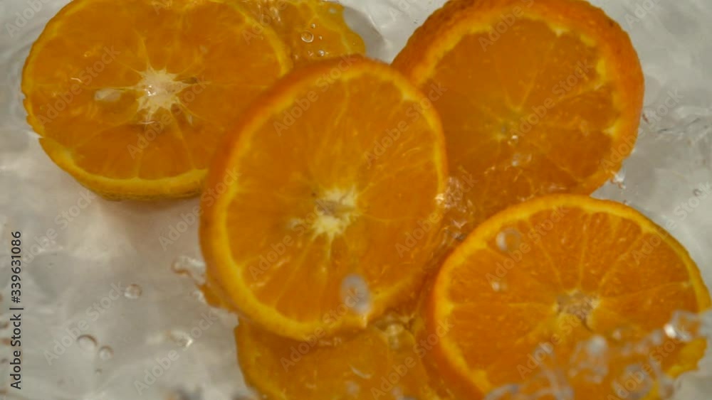 Slices of orange fruit fall in the water. Slow motion, background Slices of orange fruit fall in the water. Slow motion, background