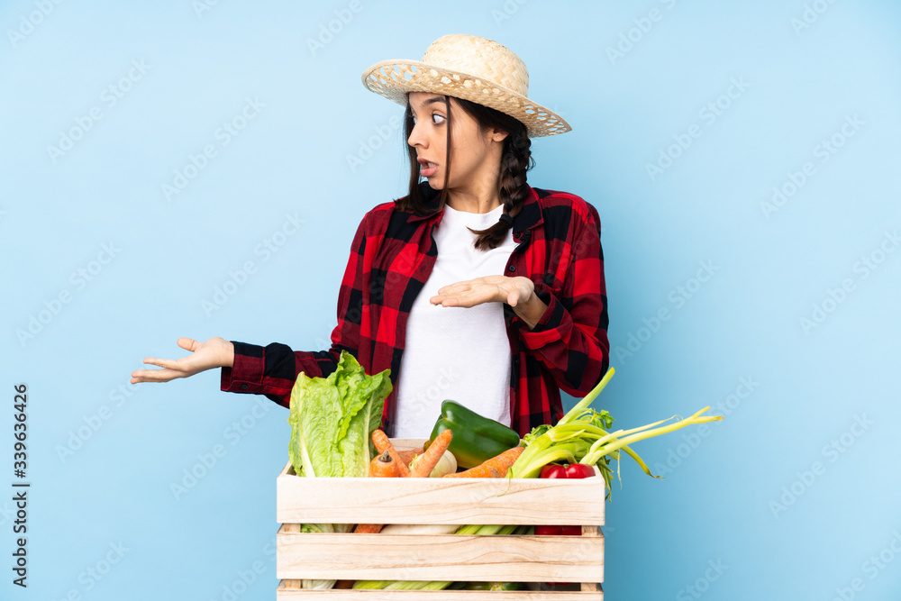 Young farmer Woman holding fresh vegetables in a wooden basket with surprise facial expression