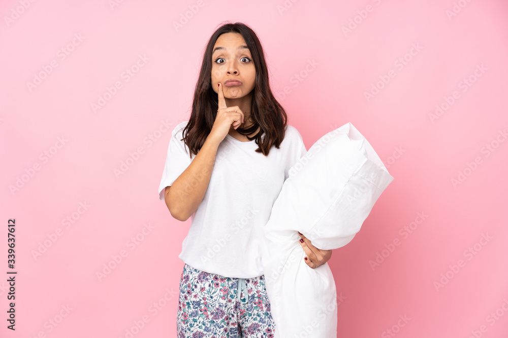 Young woman in pajamas isolated on pink background and looking front Young woman in pajamas isolated on pink background and looking front
