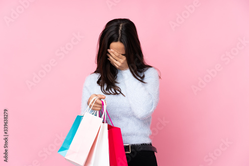 Young woman with shopping bag over isolated pink background with tired and sick expression