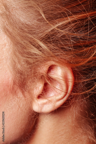 Color closeup picture of blond haired girl ear, it looks tender and sensual photo