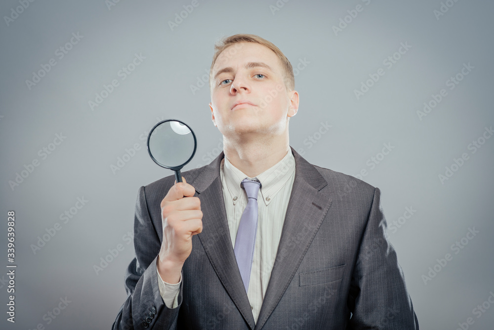 portrait of a young man holding a magnifying glass portrait of a young man holding a magnifying glass