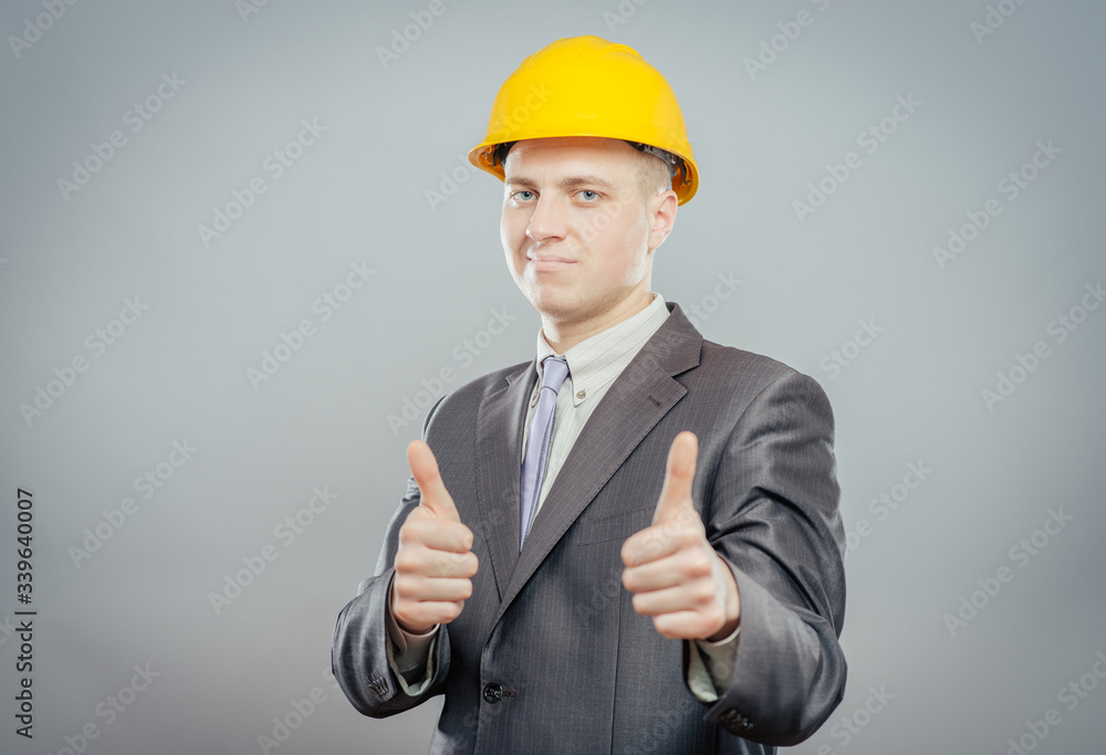 young man in a yellow hard hat showing thumb up young man in a yellow hard hat showing thumb up