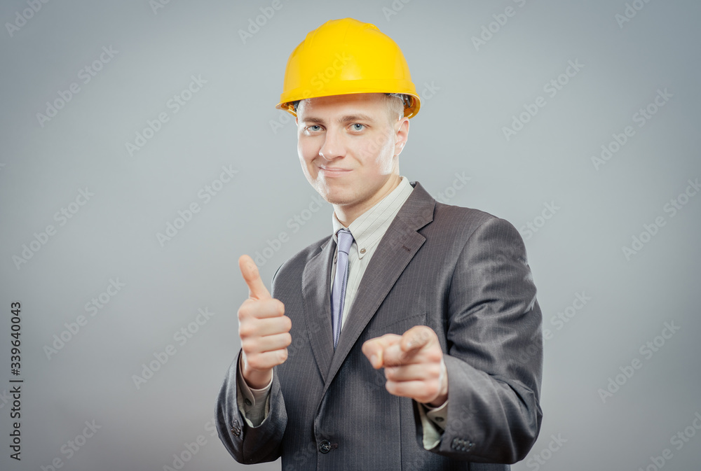young man in a yellow hard hat showing thumb up young man in a yellow hard hat showing thumb up