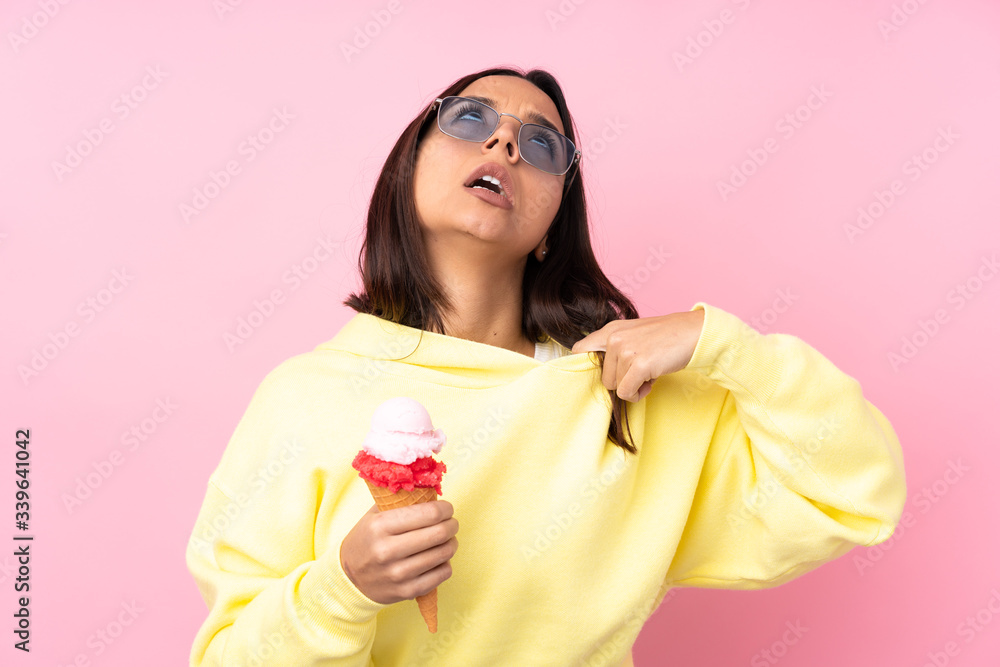 Young brunette girl holding a cornet ice cream over isolated pink background with tired and sick expression Young brunette girl holding a cornet ice cream over isolated pink background with tired and sick expression