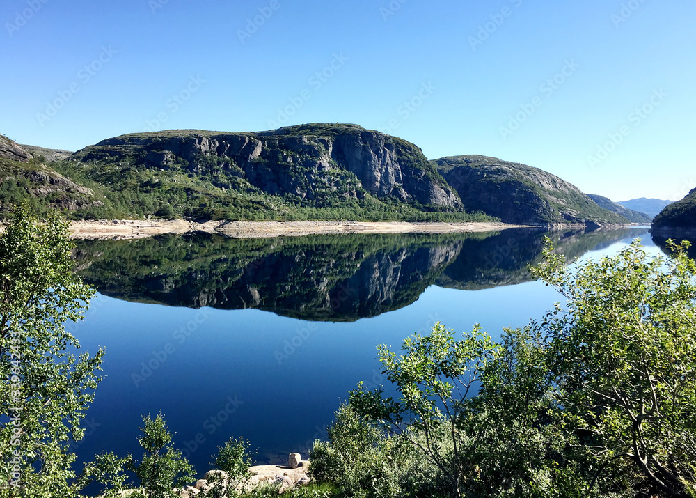 high hills are reflected in the mirror water of the lake