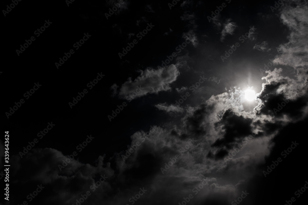Moon in the night sky among the clouds.