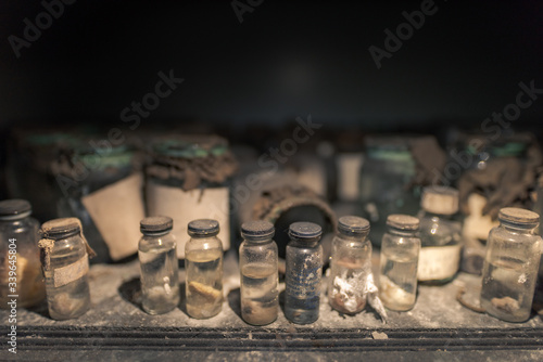 Fototapeta Naklejka Na Ścianę i Meble -  Different glass vials standing on wooden board in abandoned hospital in Pripyat, Chernobyl Exclusion Zone