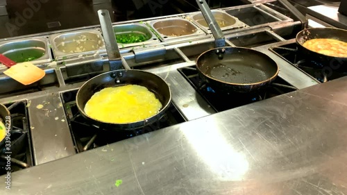 Cooking omelettes and fried eggs. Breakfast buffet in restaurant in hotel. 4K