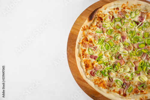 italian pizza with bacon and onions on a white plate