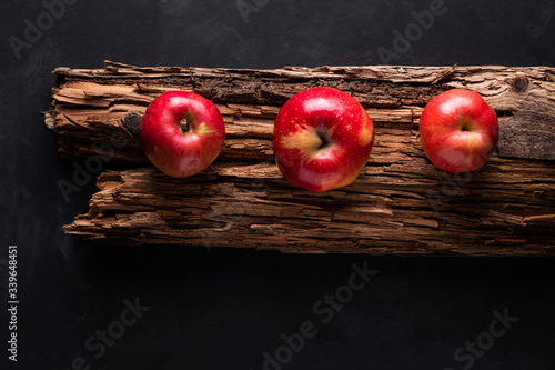 Bild auf Leinwand red apples on an old wooden board in low key