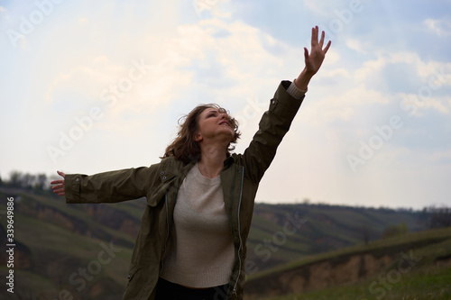 Alone girl on beautiful mountain view feeling free with wind and sky. Isolated woman on nature background, freedom, post apocalypse