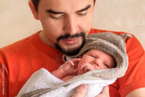 Картината върху платно Young father holding in arms little newborn baby daughter after bathing