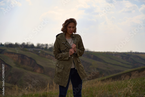 Alone girl on beautiful mountain view feeling free with wind  and sky. Isolated woman on nature background, freedom, post apocalypse