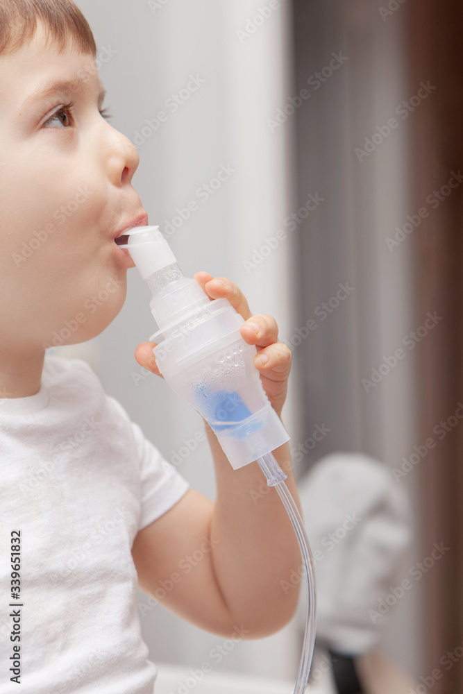 The boy makes inhalations. Treatment at home. Disease prevention The boy makes inhalations. Treatment at home. Disease prevention