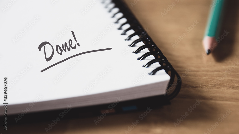 Front view of pencil and open notebook with handwritten text Done. Front view of pencil and open notebook with handwritten text Done.