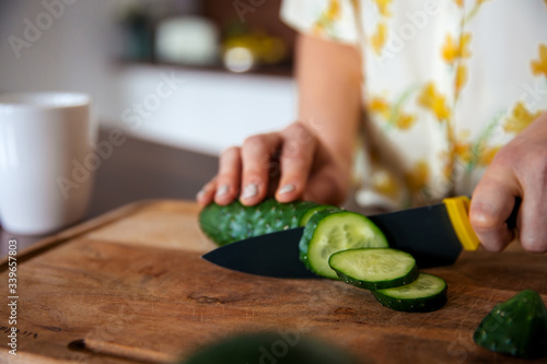 Woman with knife cuts vegetables. The concept of eco-friendly products for cooking photo