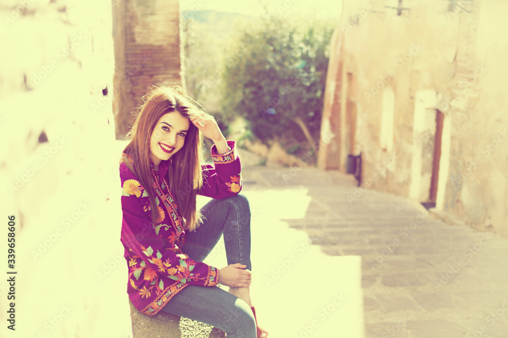 Obraz premium beautiful young girl sitting on the streets of the old town
