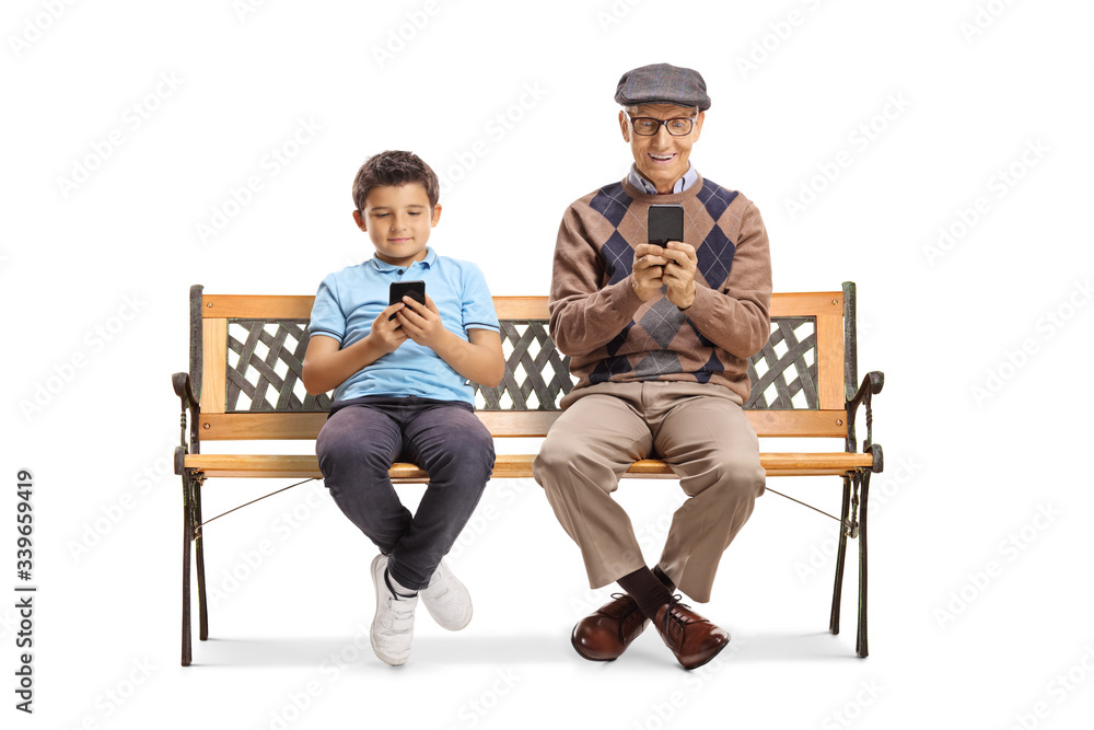 Grandfather and grandson sitting on a bench and typing on mobile phones Grandfather and grandson sitting on a bench and typing on mobile phones