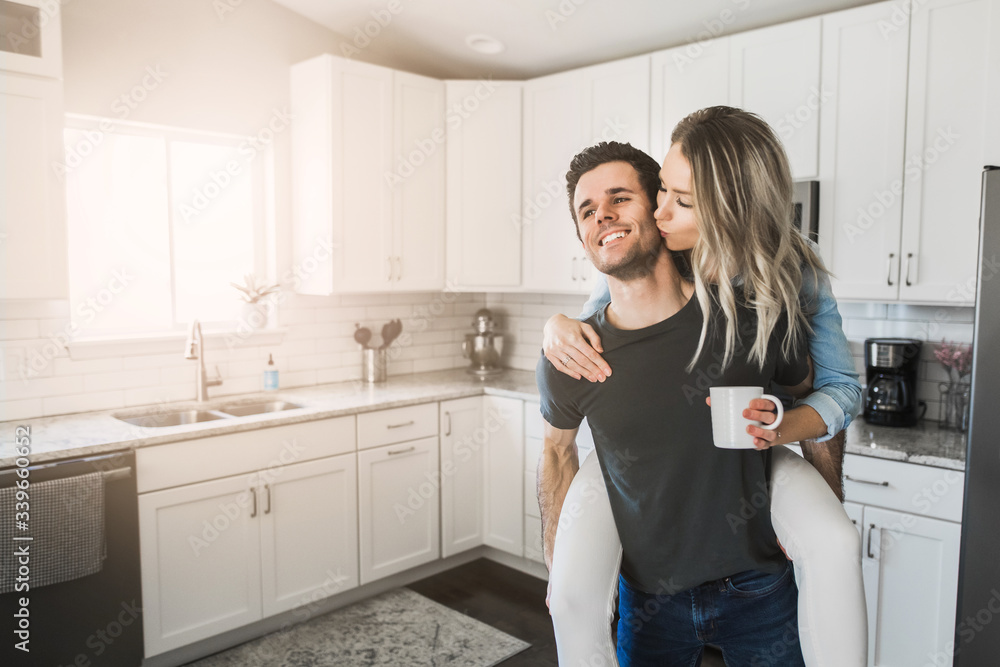 young married couple flirting in their clean kitchen young married couple flirting in their clean kitchen
