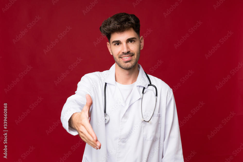 Young man over isolated background with doctor gown and making a deal Young man over isolated background with doctor gown and making a deal