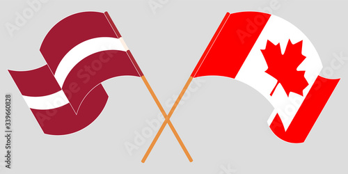 Crossed and waving flags of Latvia and Canada
