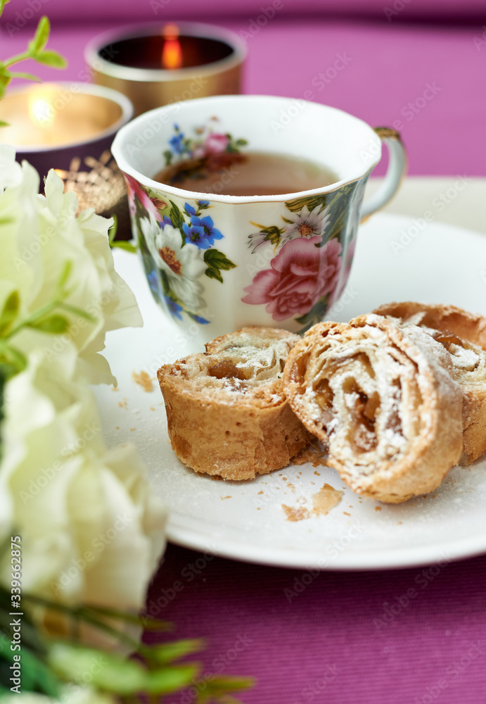 cup of tea and puff pastry roll with apple and raisins cup of tea and puff pastry roll with apple and raisins