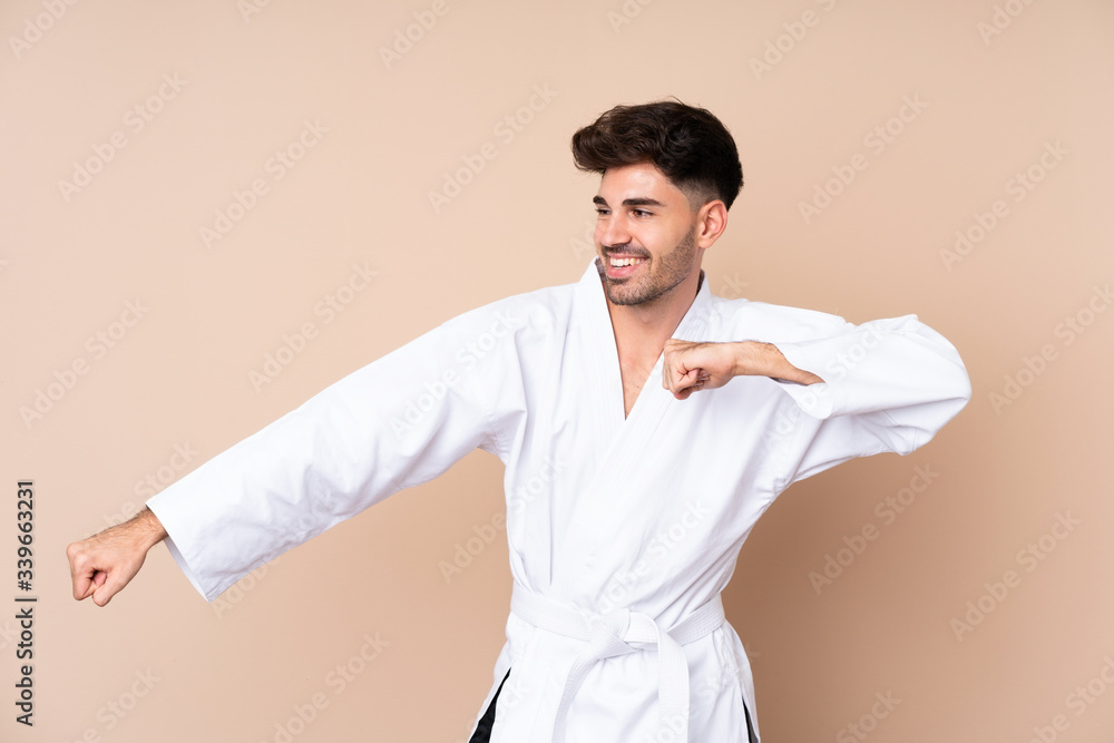 Young man over isolated background doing karate Young man over isolated background doing karate