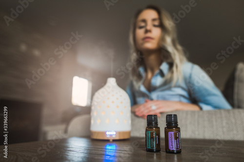 Young woman smelling her essential oil diffuser photo