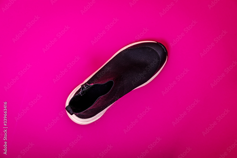 Beautiful fashionable socks sneakers on a pink background. Minimal design of . Stylish black sneakers. Training time concept. Beautiful fashionable socks sneakers on a pink background. Minimal design of . Stylish black sneakers. Training time concept.