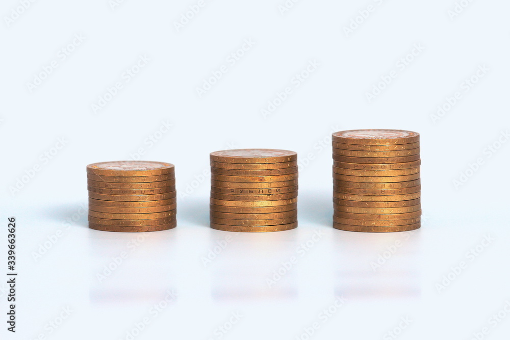 Piles of golden metallic coins. Columns of coins of different heights. The concept of business, economy, finance, investment and prices. Place for text and background for design. Piles of golden metallic coins. Columns of coins of different heights. The concept of business, economy, finance, investment and prices. Place for text and background for design.