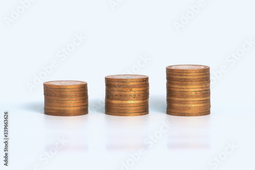 Piles of golden metallic coins. Columns of coins of different heights. The concept of business, economy, finance, investment and prices. Place for text and background for design.