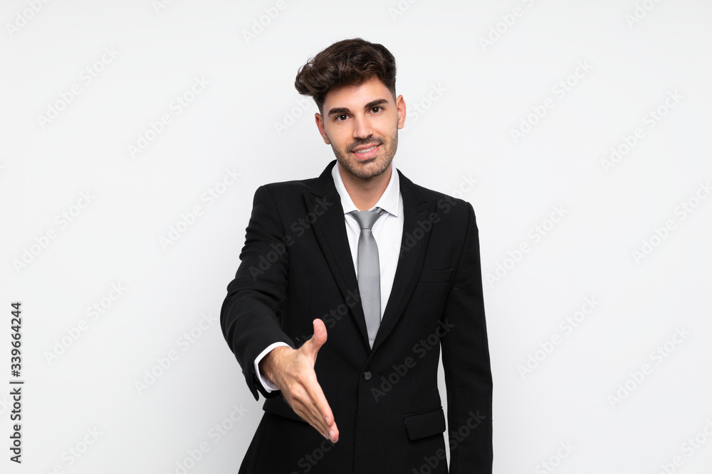 Young businessman over isolated white background handshaking after good deal Young businessman over isolated white background handshaking after good deal